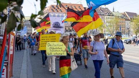 Bei einer Demonstration gegen die Politik der Bundesregierung in der Münchner Innenstadt tragen Teilnehmer Plakate, Deutschlandfahnen und Fahnen der Partei AfD.