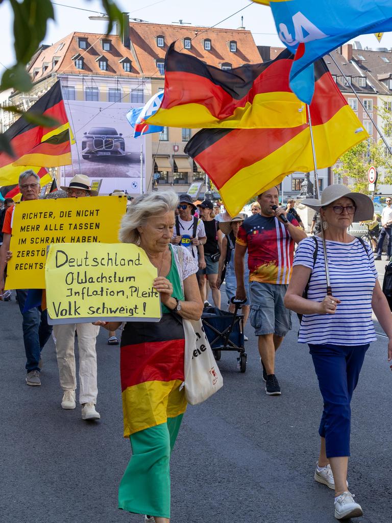 Bei einer Demonstration gegen die Politik der Bundesregierung in der Münchner Innenstadt tragen Teilnehmer Plakate, Deutschlandfahnen und Fahnen der Partei AfD.