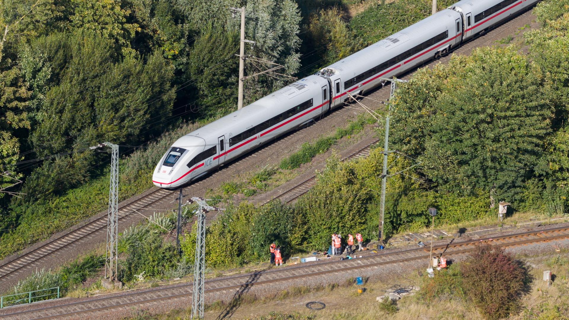 Mitarbeiter der Deutschen Bahn arbeiten nach einem Brand an einer Bahnstrecke in der Nähe eines Stellwerkes, als ein ICE der Deutschen Bahn von Berlin nach Hannover vorbeifährt. Mitarbeiter der Deutschen Bahn arbeiten nach einem Brand an einer Bahnstrecke in der Nähe eines Stellwerkes, als ein ICE der Deutschen Bahn von Berlin nach Hannover vorbeifährt.