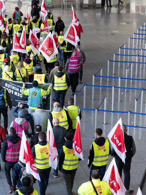 Verdi-Mitglieder ziehen beim Warnstreik in einem Protestzug durch das Terminal 1 im Flughafen Frankfurt (10.3.2025)