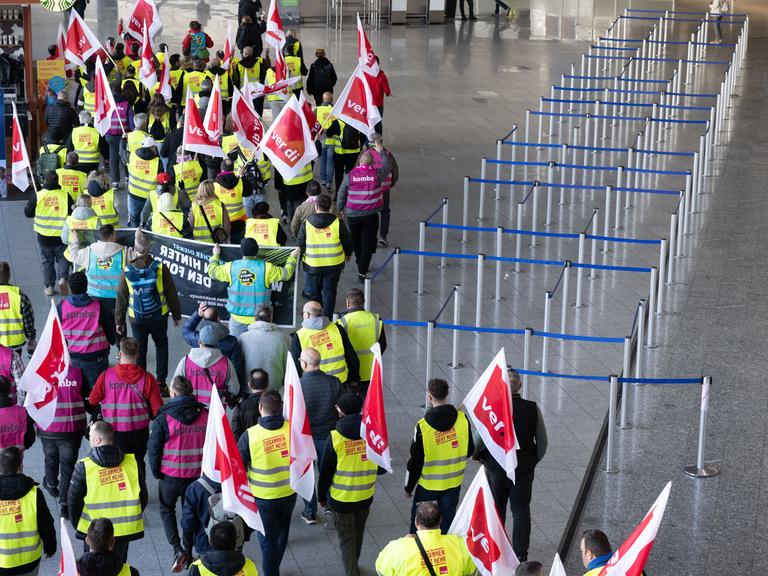 Verdi-Mitglieder ziehen beim Warnstreik in einem Protestzug durch das Terminal 1 im Flughafen Frankfurt (10.3.2025)