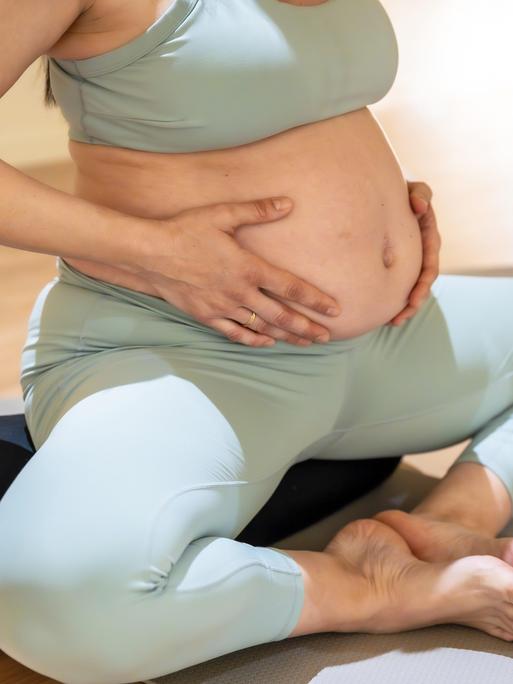 Schwangere Frau beim Yoga Kurs