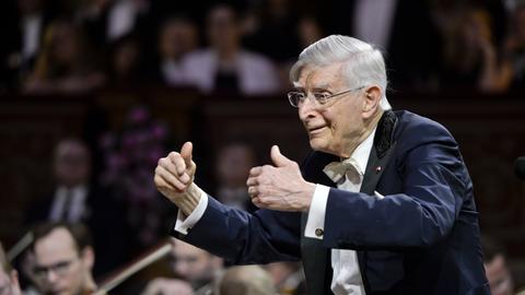 Der Dirigent Herbert Blomstedt dirigiert mit erhobenen Händen.