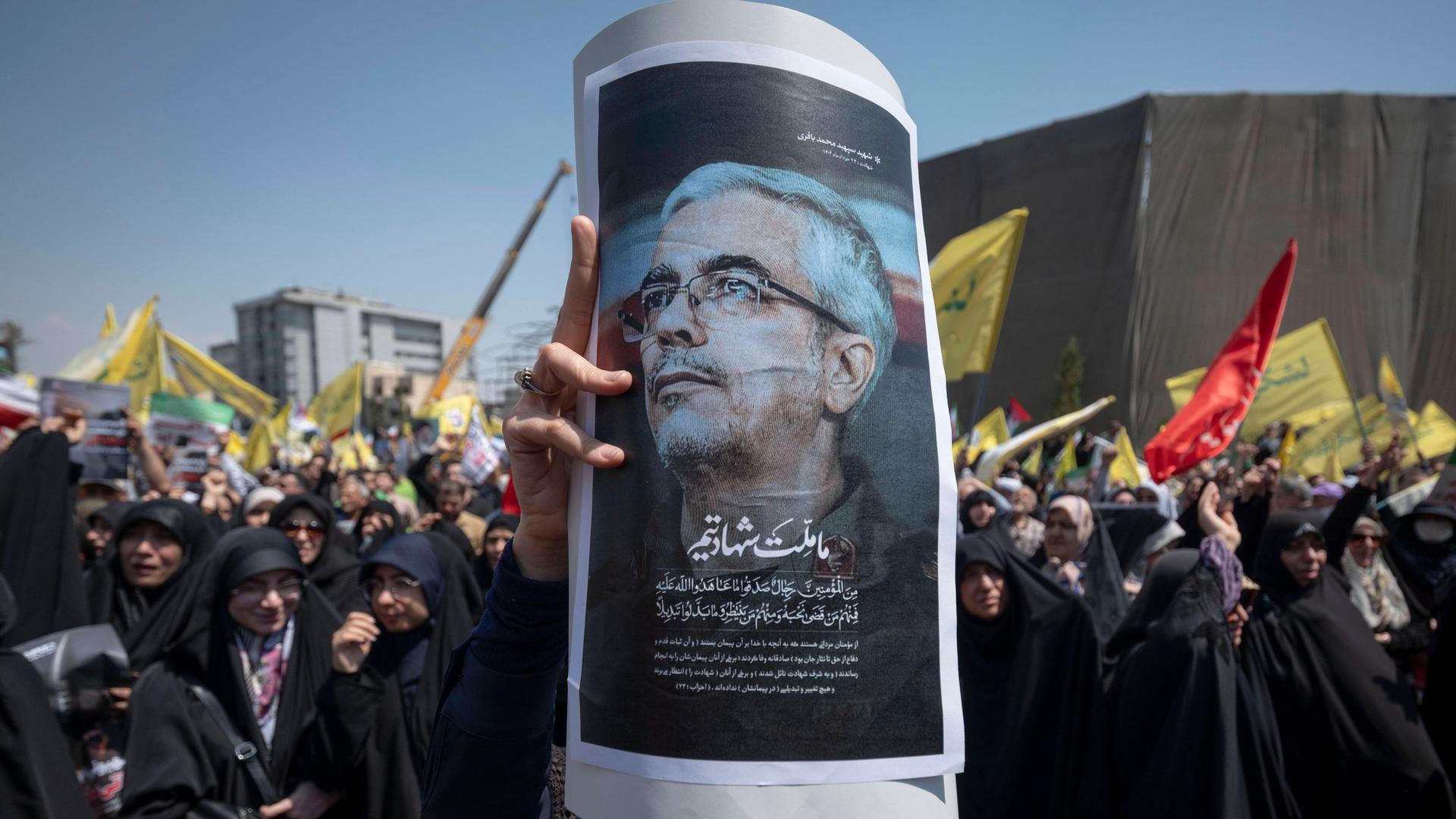Aufgebrachte Menschen in Teheran halten ein Poster von  Mohammed Bagheri hoch. Der iranische Armeechef wurde bei israelischen Angriffen auf den Iran getötet. 