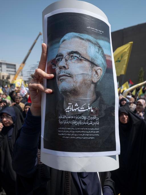 Aufgebrachte Menschen in Teheran halten ein Poster von  Mohammed Bagheri hoch. Der iranische Armeechef wurde bei israelischen Angriffen auf den Iran getötet. 