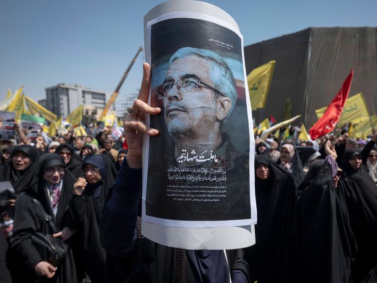 Aufgebrachte Menschen in Teheran halten ein Poster von  Mohammed Bagheri hoch. Der iranische Armeechef wurde bei israelischen Angriffen auf den Iran getötet. 