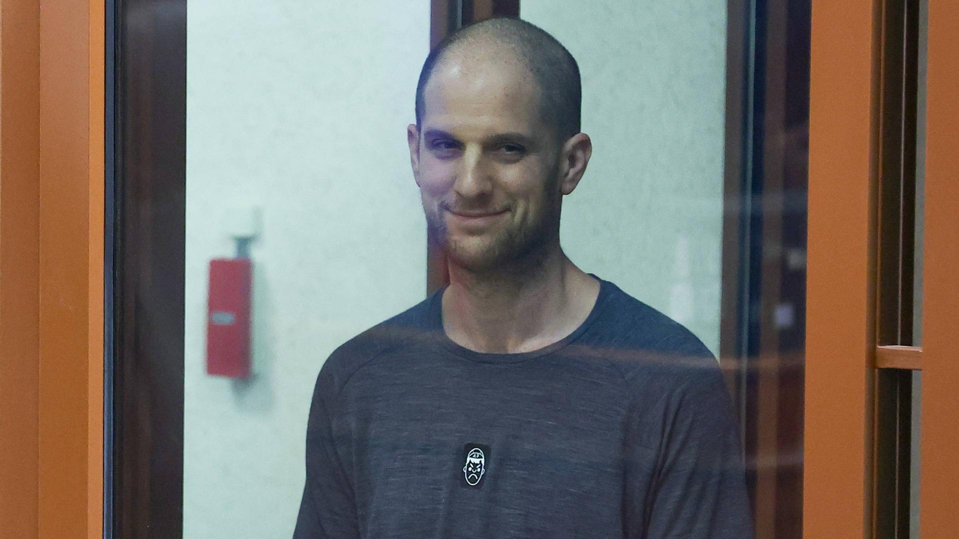 Der US-Journalist Evan Gershkovich während der Gerichtsverhandlung. Er ist hinter einer Glasscheibe zu sehen.