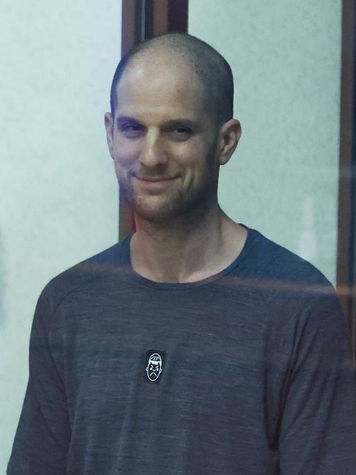 Der US-Journalist Evan Gershkovich während der Gerichtsverhandlung. Er ist hinter einer Glasscheibe zu sehen.