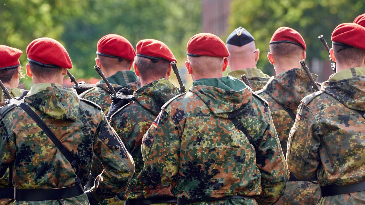 Eine Gruppe von Soldaten der Deutschen Bundeswehr in Tarnuniformen stehen in Formation mit Gewehr Bewaffnet bei einem Militär Appell