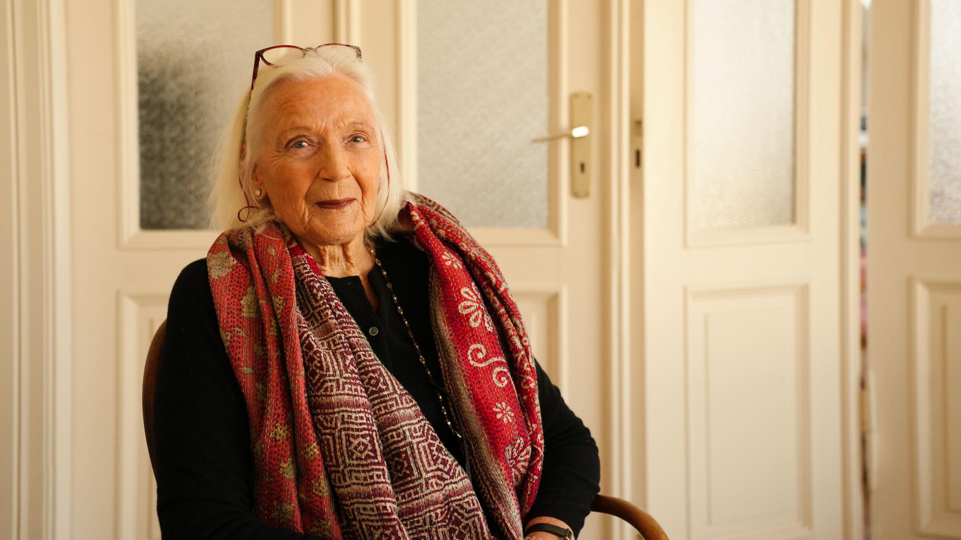 Die Autorin Gabriele von Arnim ist weißhaarig und trägt einen roten Schal. 













