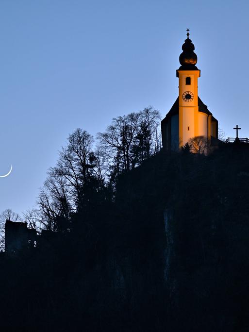 Die Wallfahrtskirche St.Pankraz steht auf dem Karlstein, einem Felsen, bei Bad Reichenhall und wird von der Abendsonne angestrahlt.