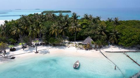Luftaufnahme einer einsamen Insel mit Sandbank, Boot und Palmen auf den Malediven.