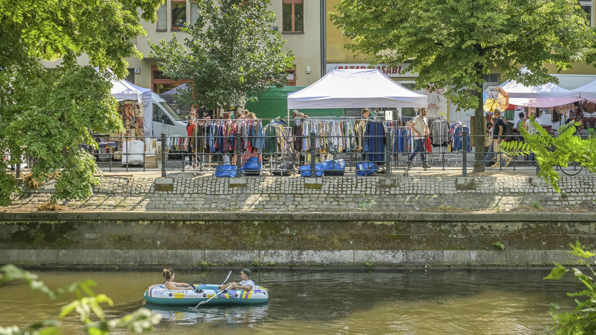 Die Straße Maybachufer in Berlin-Neukölln - mit Blick von der gegenüberliegenden Uferseite auf den Landwehrkanal und einen Teil des Wochenmarkts auf dem Maybachufer Die Straße Maybachufer in Berlin-Neukölln - mit Blick von der gegenüberliegenden Uferseite auf den Landwehrkanal und einen Teil des Wochenmarkts auf dem Maybachufer