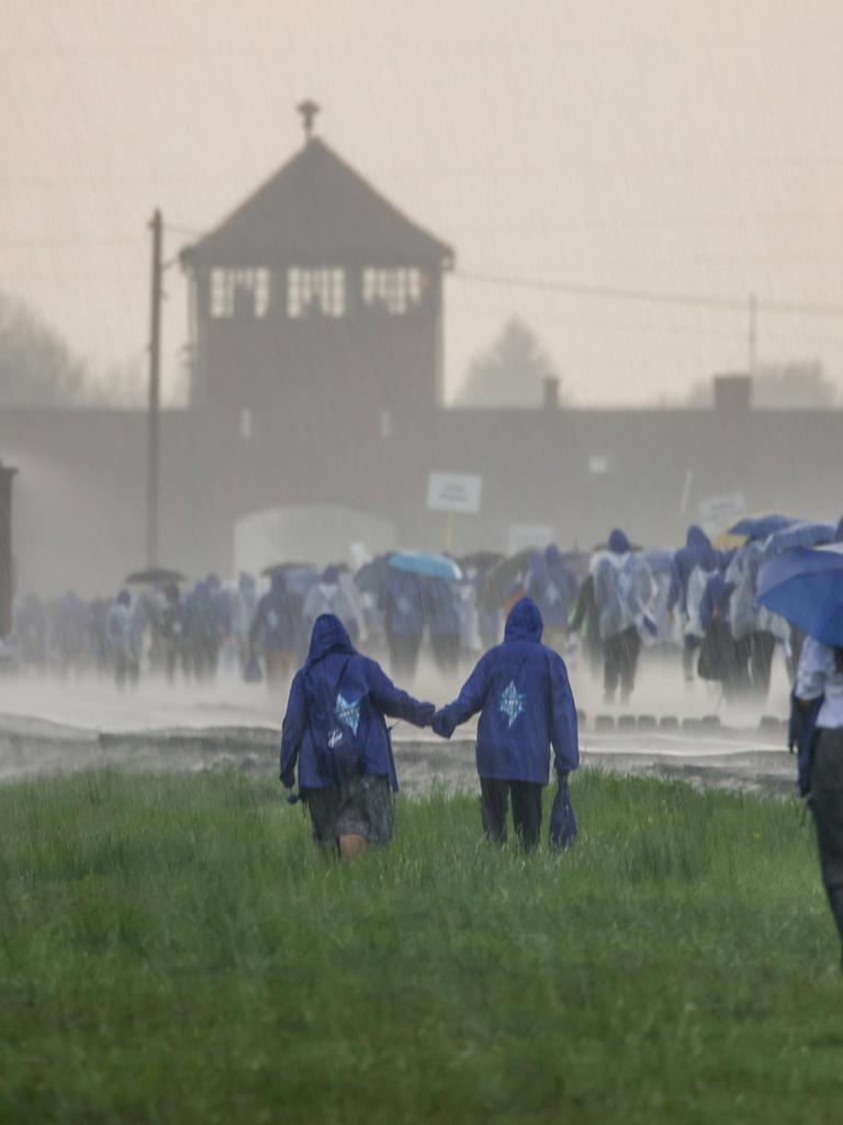 Das ehemalige Konzentrationslager Ausschwitz wird von heftigem Niederschlag heimgesucht. Auf dem Bild sind mehrere junge Leute zu sehen, die dem KZ einen Besuch abstatten. 