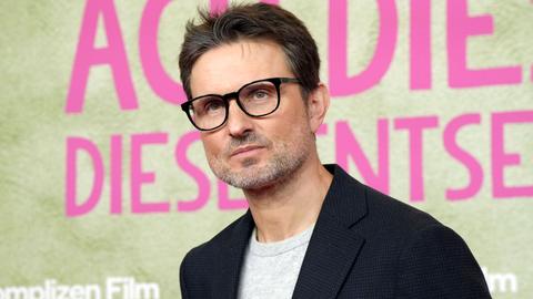 Simon Verhoeven posiert während der Premiere seines Kinofilms "Ach, diese Lücke, diese entsetzliche Lücke" vor einem Plakat im Mathäser Filmpalast