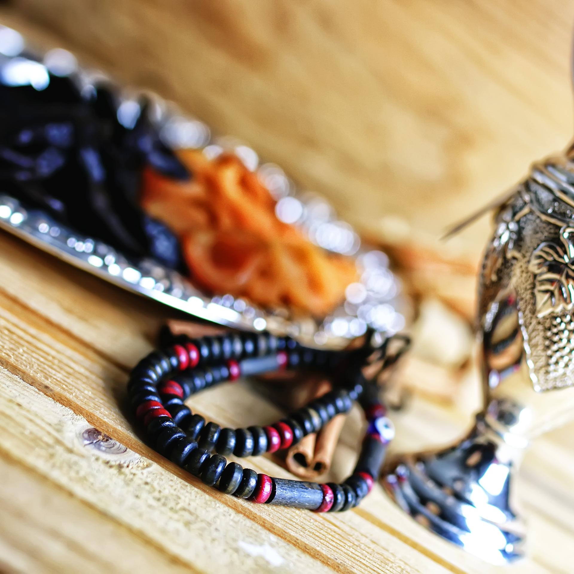 Trockenobst liegt auf einer Silberplatte, daneben befinden sich eine Gebetskette und eine silberne Karaffe