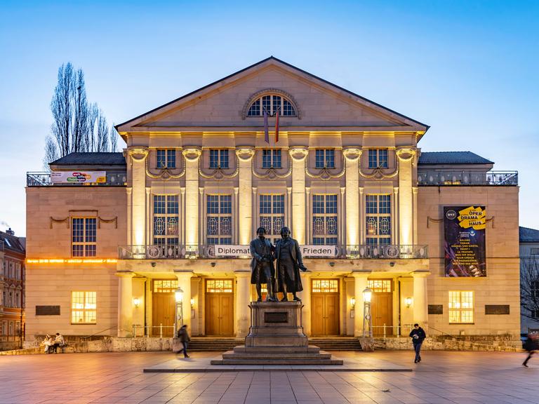 Das Deutsche Nationaltheater mit dem Goethe-und-Schiller-Denkmal in der Abenddämmerung.