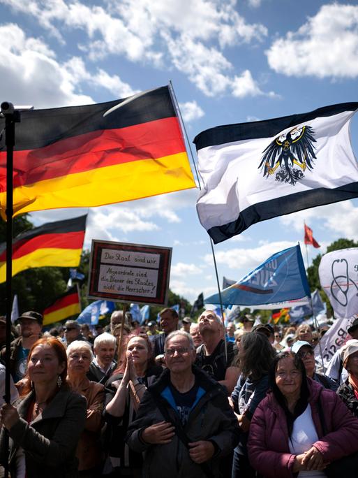 Demonstranten mit Deutschlandfahne und Preußenflagge beim "Friedensmarsch" vom Netzwerk Deutschland am 24.05.2025 in Berlin 