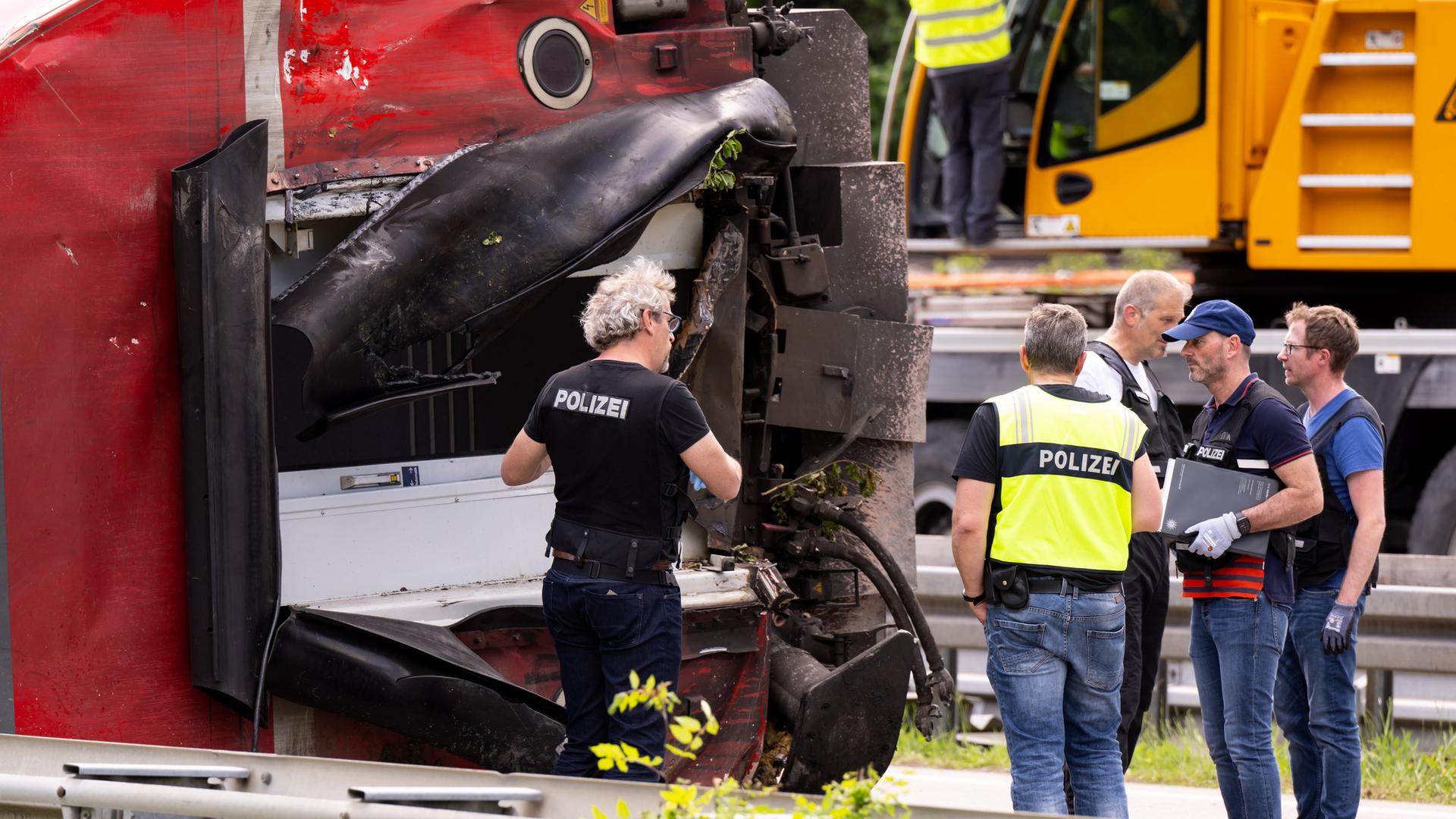 Polizisten untersuchen am zweiten Tag nach einem schweren Zugunglück einen Eisenbahnwagen Polizisten untersuchen am zweiten Tag nach einem schweren Zugunglück einen Eisenbahnwagen