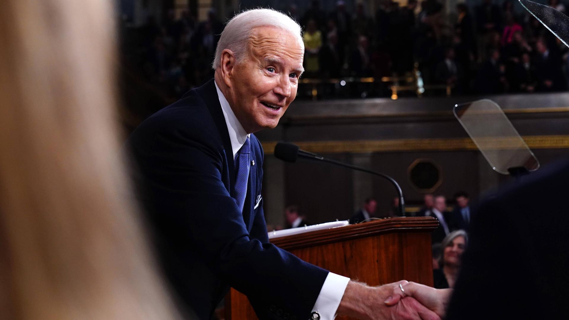 US-Präsident Joe Biden reicht jemanden die Hand.