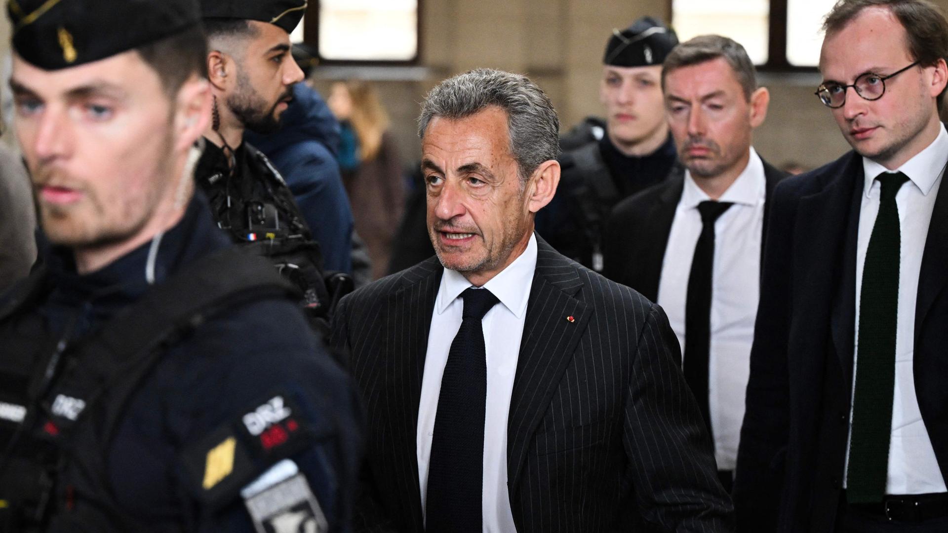 Frankreich, Paris: Frankreichs ehemaliger Präsident Nicolas Sarkozy (M) kommt zur Urteilsverkündung in seinem Berufungsverfahren im sogenannten Bygmalion-Fall im Gerichtsgebäude.