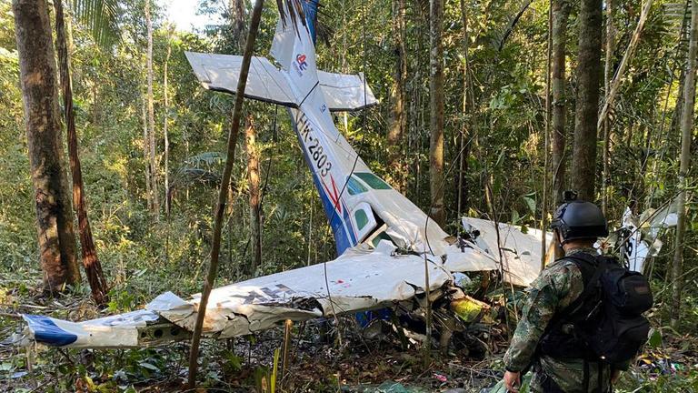 Das Wrack eines abgestürzten Flugzeugs liegt im Dschungel. Im Vordergrund steht ein Soldat. Das Wrack eines abgestürzten Flugzeugs liegt im Dschungel. Im Vordergrund steht ein Soldat.