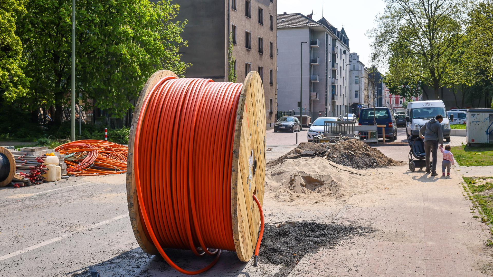 Eine riesige Kabeltrommel mit Glasfaserkabel steht auf einer Straße in Duisburg