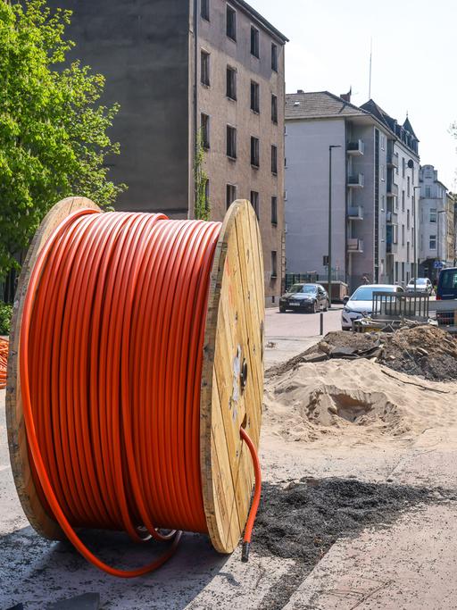 Eine riesige Kabeltrommel mit Glasfaserkabel steht auf einer Straße in Duisburg