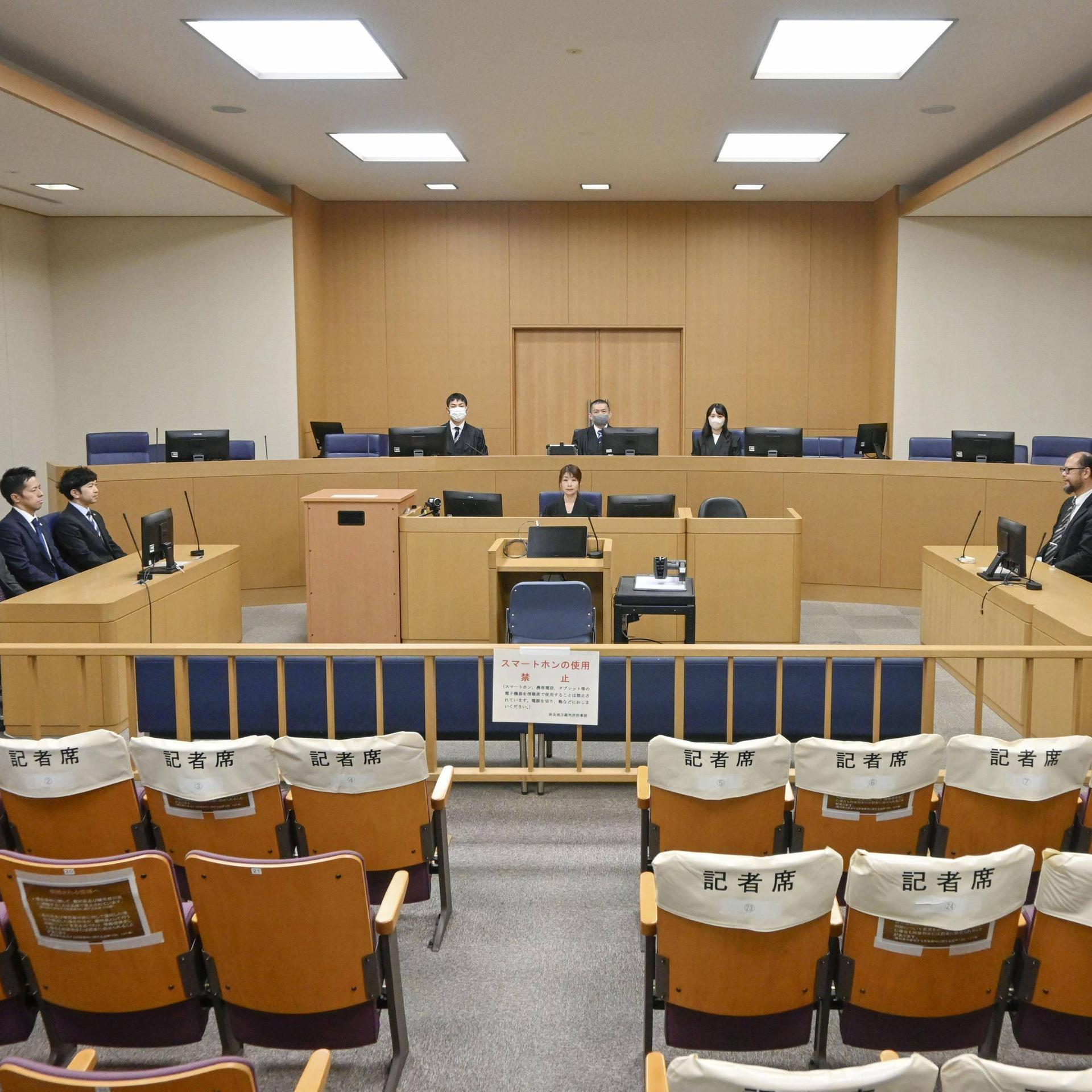 Aufnahme der Richterbank am Gericht im westjapanischen Nara, mehrere Menschen in Anzügen sitzen auf den Rängen.
