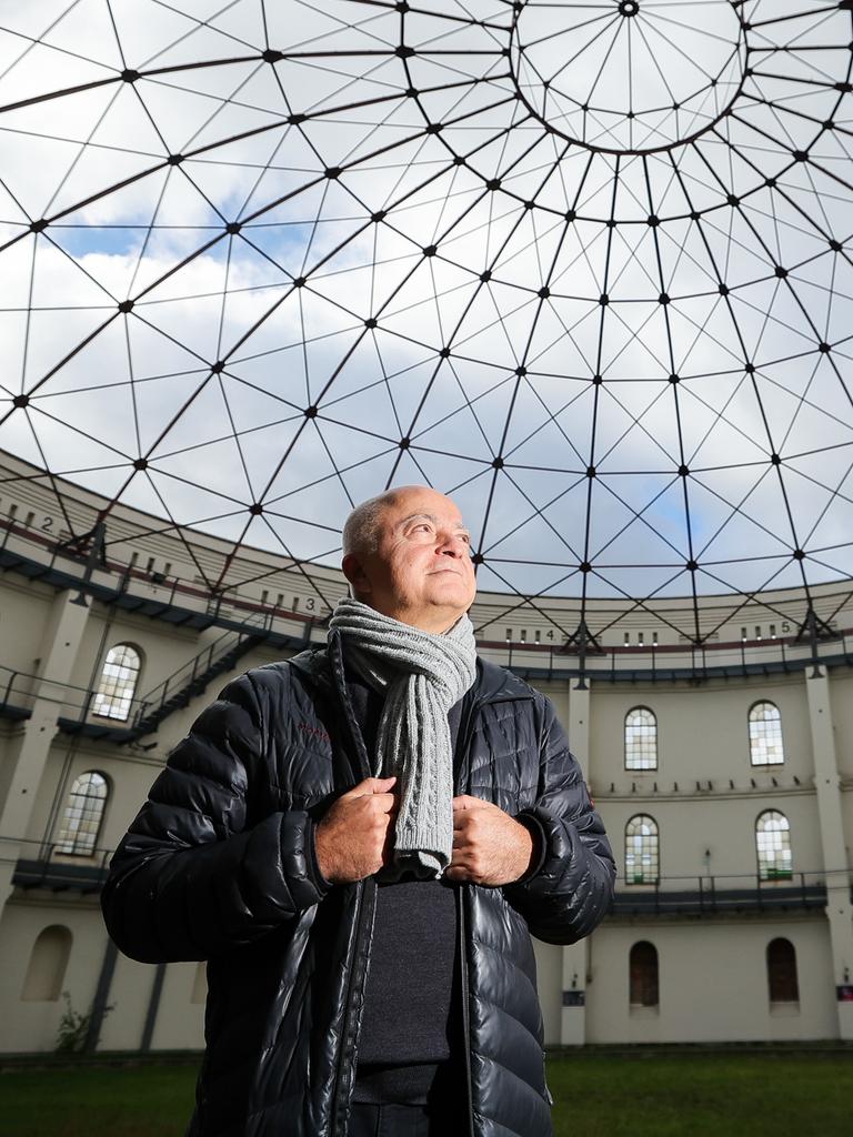 Yadegar Asisi steht in einem für Events genutzten Gasometer und schaut zur runden Glasdecke hoch.