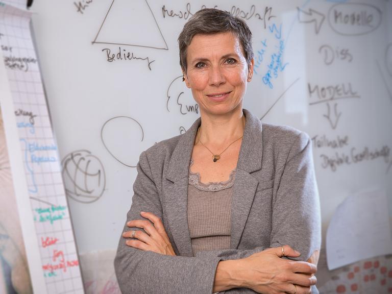 Die Professorin Alke Martens steht vor einer mit Berechnungen vollgeschriebenen Wand.