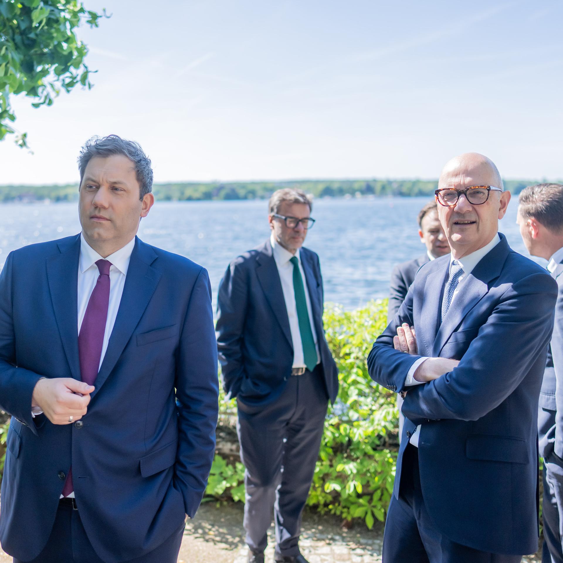Die fünf Minister stehen auf einer Terasse am Rande des Sees. Klingbeil und Giorgetti stehen vorne. 