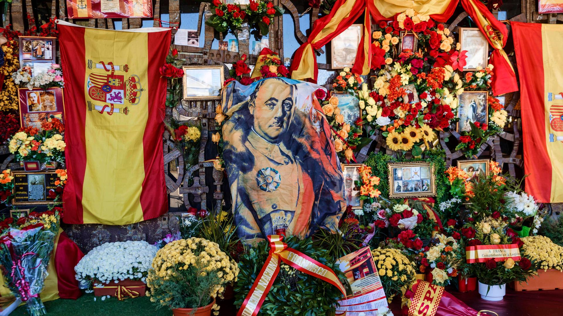 Grabmal des Diktators Francisco Franco auf dem Friedhof von Mingorrubio-El Pardo in Madrid, umsäumt von spanischen Flaggen, Blumen und Gedenkkarten.