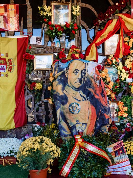 Grabmal des Diktators Francisco Franco auf dem Friedhof von Mingorrubio-El Pardo in Madrid, umsäumt von spanischen Flaggen, Blumen und Gedenkkarten.