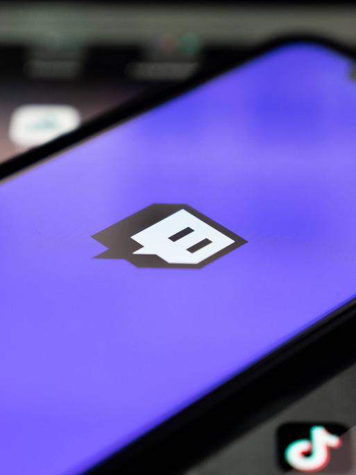 Blick auf ein Handy, auf dem Bildschirm ist das Twitch-Logo der App zu sehen Blick auf ein Handy, auf dem Bildschirm ist das Twitch-Logo der App zu sehen
