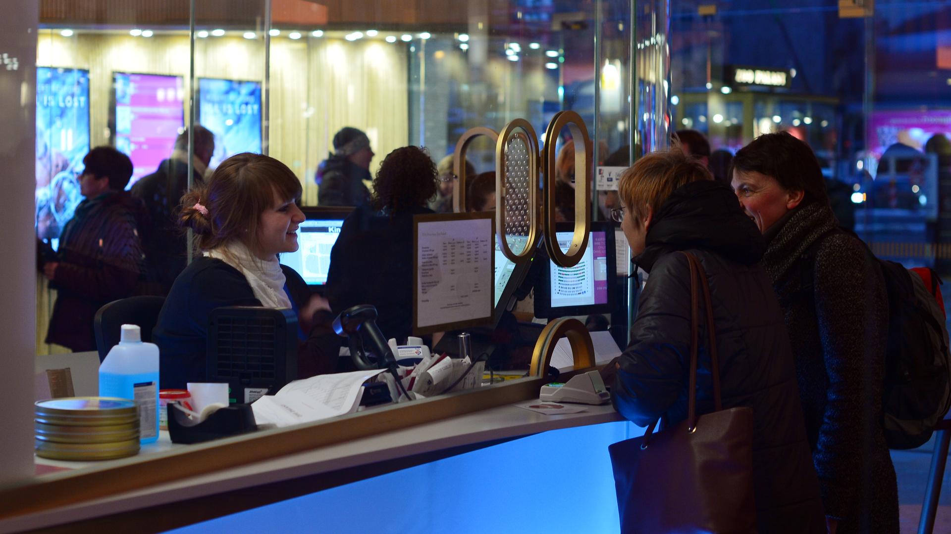 Kinobesucher stehen im Eingangsbereich des Berliner Kinos Zoo Palast an der Kinokasse