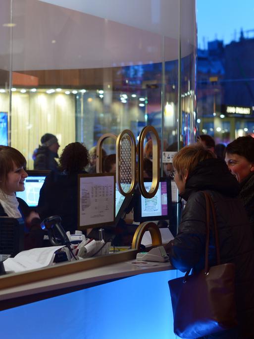 Kinobesucher stehen im Eingangsbereich des Berliner Kinos Zoo Palast an der Kinokasse