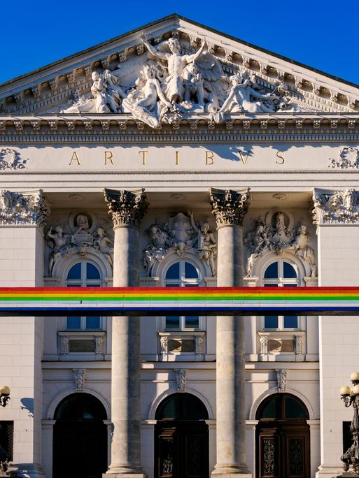 Symbolträchtiges Gebäude: Die Zachęta-Galerie in Warschau. Im Vordergrund ist ein Bogen aus den Farben des Regenbogens zu sehen, der für die LGBTQ-Community, also unter anderem Lesben und Schwule, steht.