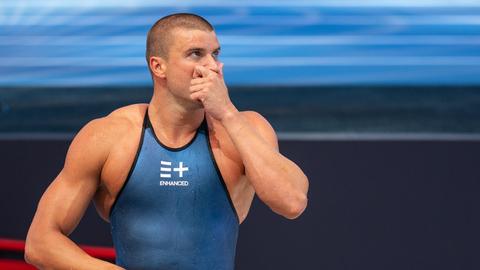 Der deutsche Schwimmer Marius Kusch steht am Beckenrand in blauer Schwimmbekleidung, die den Schriftzug der Enhanced Games trägt Der deutsche Schwimmer Marius Kusch steht am Beckenrand in blauer Schwimmbekleidung, die den Schriftzug der Enhanced Games trägt