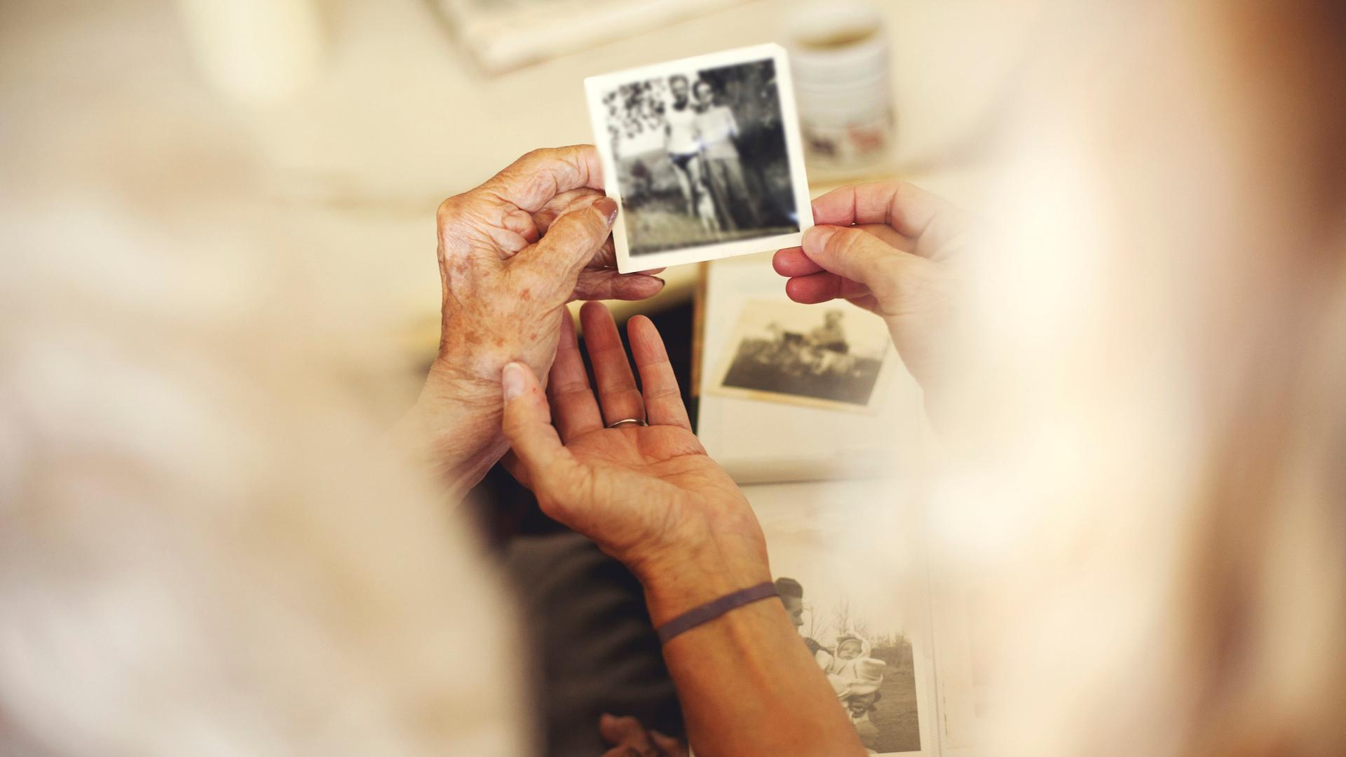 Hände, die alte Familienfotos halten