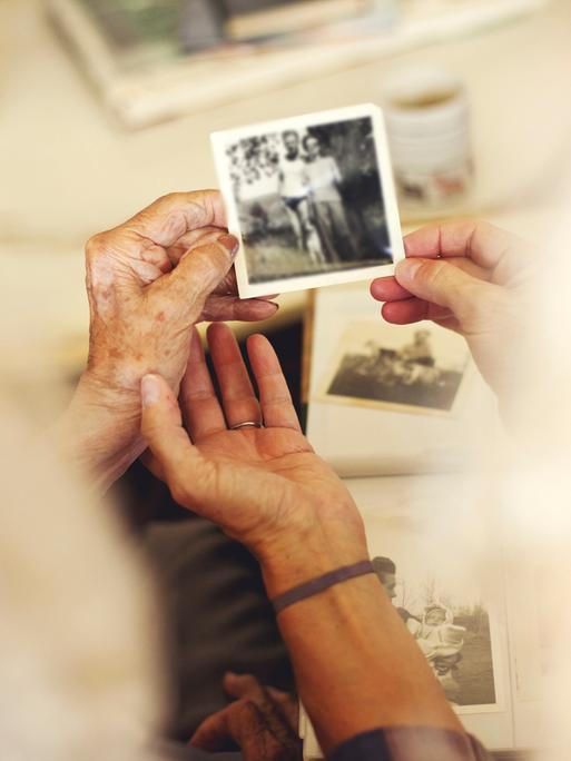 Hände, die alte Familienfotos halten