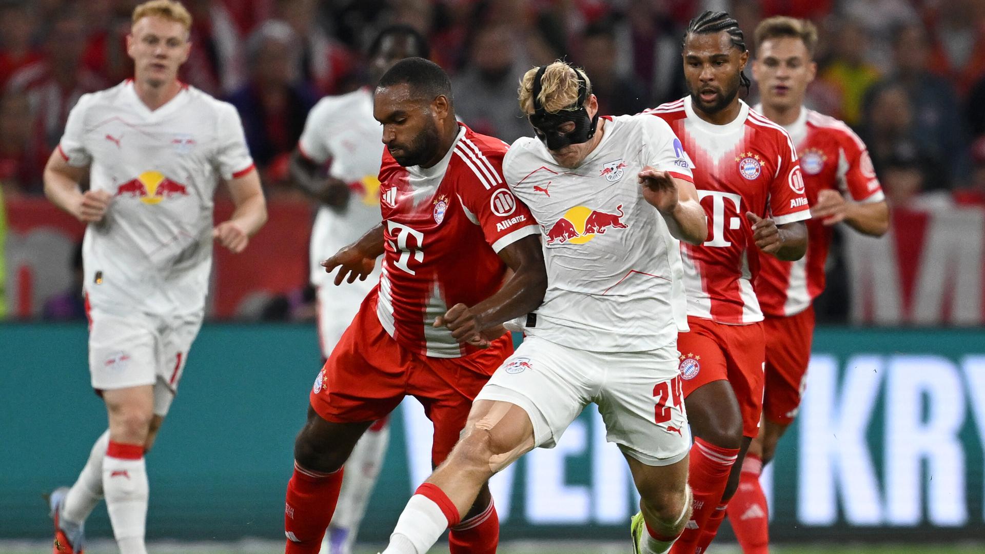 Szene aus dem Bundesliga-Auftaktspiel Bayern München gegen Leipzig; Spieler beider Mannschaften kämpfen um den Ball. Szene aus dem Bundesliga-Auftaktspiel Bayern München gegen Leipzig; Spieler beider Mannschaften kämpfen um den Ball.
