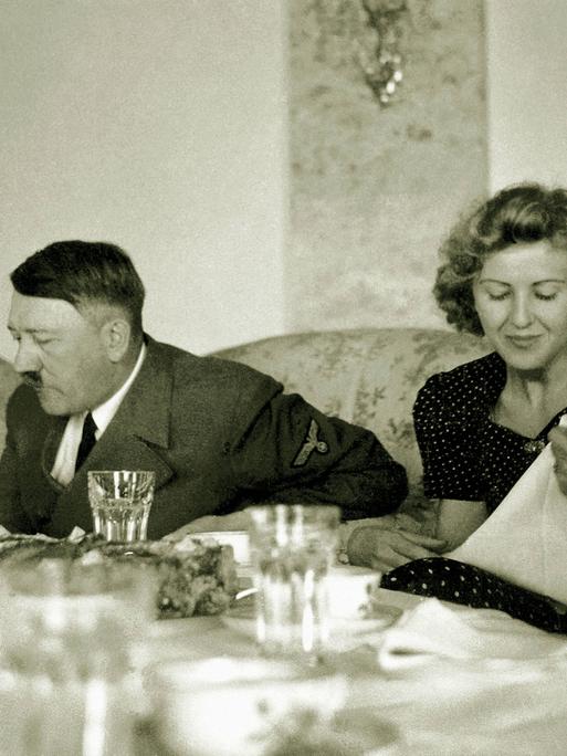 Schwarz-weiß-Aufnahme von Eva Braun und Adolf Hitler in einem Teehaus 