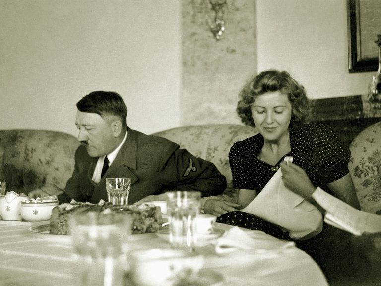 Schwarz-weiß-Aufnahme von Eva Braun und Adolf Hitler in einem Teehaus 