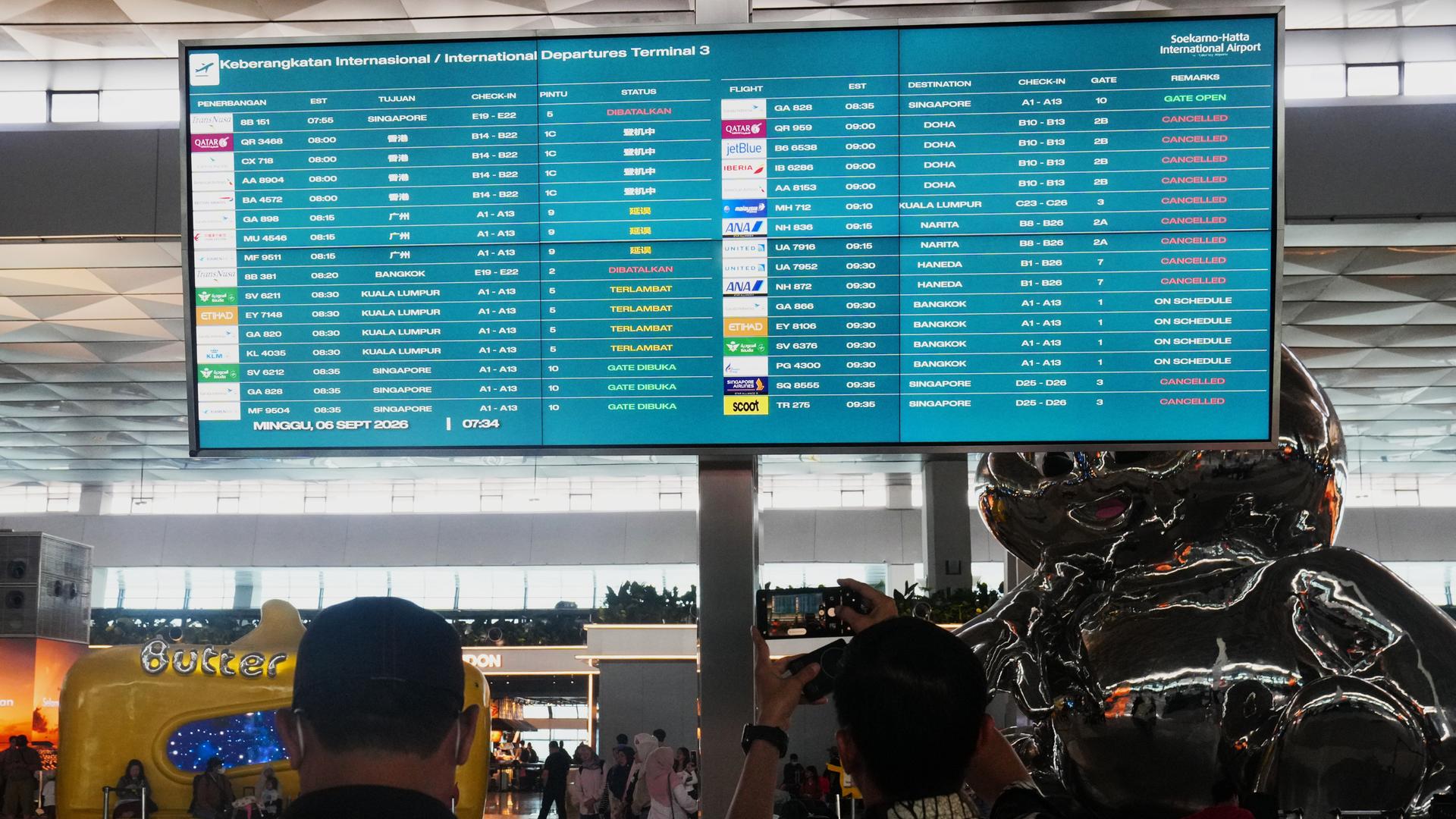 Reisende gehen im indonesischen Hauptstadtflughafen Soekarno-Hatta an einer Informationstafel vorbei, auf der Flugausfälle angezeigt werden. Reisende gehen im indonesischen Hauptstadtflughafen Soekarno-Hatta an einer Informationstafel vorbei, auf der Flugausfälle angezeigt werden.