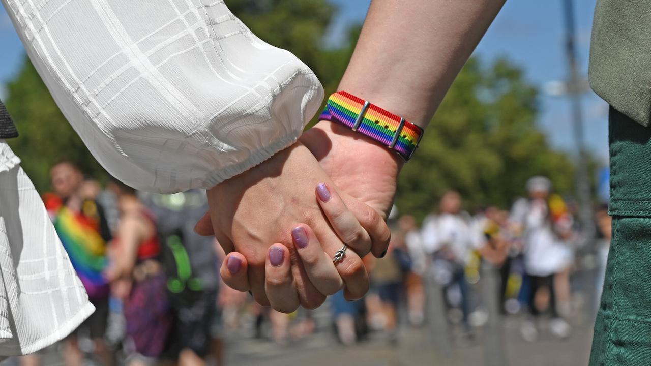 Frauen halten sich Händchen während der Demonstration zum Christopher Street Day (CSD). Frauen halten sich Händchen während der Demonstration zum Christopher Street Day (CSD).