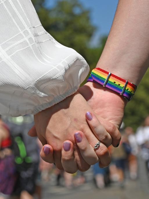 Frauen halten sich Händchen während der Demonstration zum Christopher Street Day (CSD).