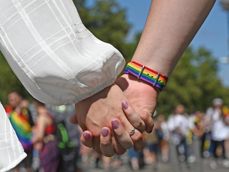 Frauen halten sich Händchen während der Demonstration zum Christopher Street Day (CSD).