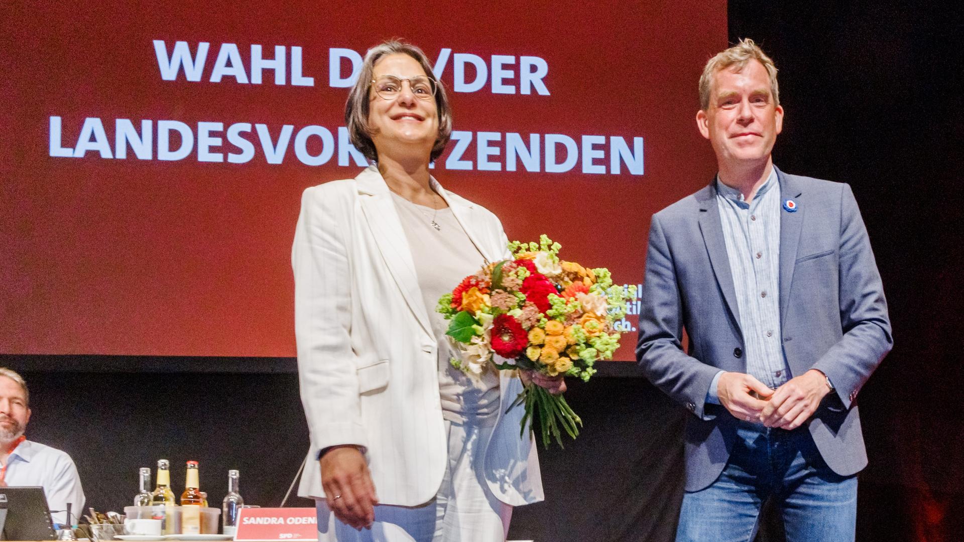 Serpil Midyatli (SPD), Fraktionsvorsitzende im Landtag, steht nach ihrer Wahl zur Landesvorsitzenden zusammen mit Ulf Kämpfer (SPD), Oberbürgermeister Kiels, auf der Bühne des Parteitags. Serpil Midyatli (SPD), Fraktionsvorsitzende im Landtag, steht nach ihrer Wahl zur Landesvorsitzenden zusammen mit Ulf Kämpfer (SPD), Oberbürgermeister Kiels, auf der Bühne des Parteitags.