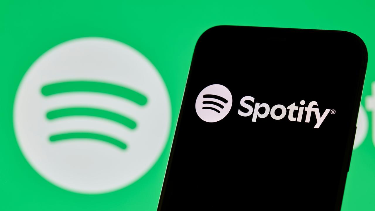 Spotify-Logo und App-Oberfläche auf dem Smartphone-Bildschirm angezeigt.